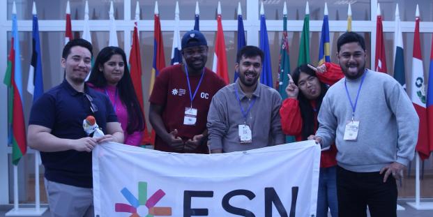 ESN volunteers holding the ESN flag in front of international flags
